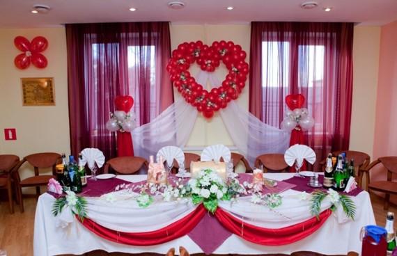 Банкетный зал украшен для свадьбы шарами и тканью